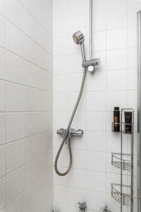 a shower in a white tiled bathroom at Delightful Moroccan Inspired Flat Hackney Sleeps 2 in London