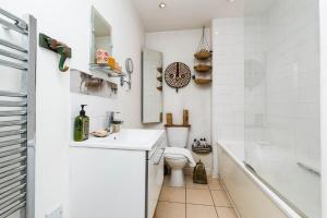 a bathroom with a sink and a toilet and a tub at Delightful Moroccan Inspired Flat Hackney Sleeps 2 in London