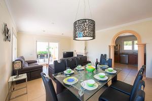 a dining room and living room with a table and chairs at Villa Almendros - PlusHolidays in Calpe