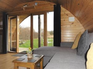 ein Wohnzimmer mit einem Bett und einem Tisch in der Unterkunft Cosy Cabins at Westfield Farm in Yarmouth