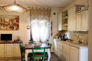a kitchen with a table and a dining room at Casa Salvia in Garda +9 photos