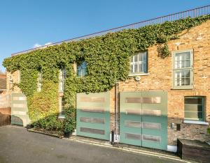 an ivy covered building with a garage at Unique,architecturally acclaimed,Notting Hill home in London