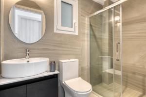 een badkamer met een toilet, een wastafel en een spiegel bij Stoa apartments in Katávolos
