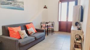 una sala de estar con un sofá y una mesa en Appartamento Tharros, en Cabras