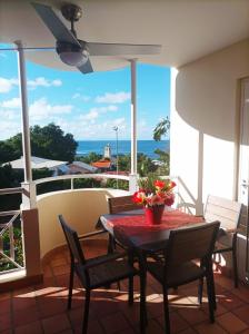 d'une table et de chaises sur un balcon avec vue sur l'océan. dans l'établissement STUDIO ROUGE GORGE TARTANE, à La Trinité