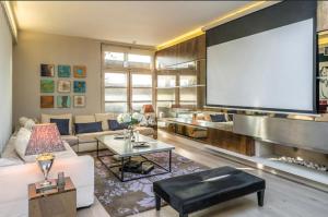 un soggiorno con divano bianco e grande schermo di Unique,architecturally acclaimed,Notting Hill home a Londra