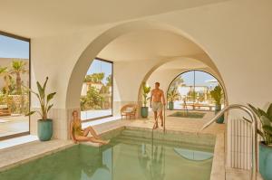 a man and a woman sitting in a swimming pool at The Signature Level at TRS Ibiza Hotel - All Inclusive Adults Only - Entrance to Clubs included in San Antonio