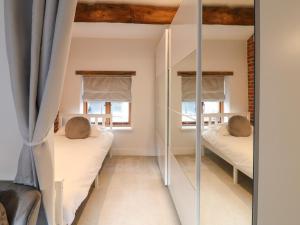 a bedroom with two beds and a mirror at The Old Dairy House in Ashbourne