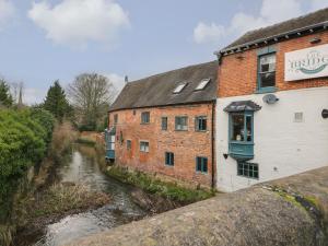 a building with a window next to a river at The Old Dairy House in Ashbourne