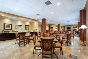 ウェストパームビーチにあるHawthorn Extended Stay by Wyndham West Palm Beachのロビーのテーブルと椅子付きのレストラン