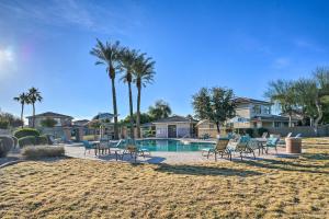 a pool with chairs and palm trees and houses at Goodyear Desert Oasis Walk to Community Pool in Goodyear