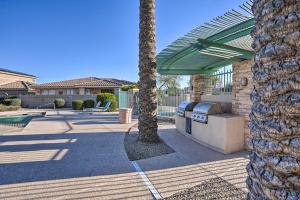 a palm tree and a grill in a courtyard at Goodyear Desert Oasis Walk to Community Pool in Goodyear