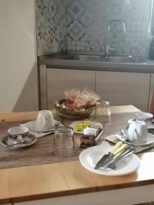 a kitchen counter with plates and utensils and a sink at Borgo dei Centenari in Orgosolo