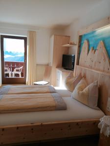 1 dormitorio con 1 cama grande y balcón en Gspoi-Hof, en Laion