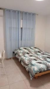 a bedroom with a bed with a curtain at One bedroom private apartment - quiet near a park in Beer Sheva