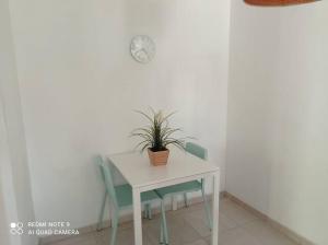 a white table and chairs with a plant on it at One bedroom private apartment - quiet near a park in Beer Sheva