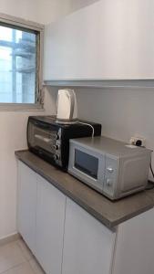 a microwave and a toaster oven on a counter at One bedroom private apartment - quiet near a park in Beer Sheva