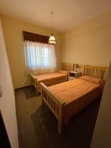 Cette chambre comprend 2 lits et une fenêtre. dans l'établissement Departamento Borgoña, à Salta