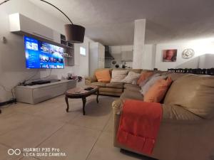 ein Wohnzimmer mit einem Sofa und einem TV in der Unterkunft villa di charme con piscina e jacuzzi tra Roma e Viterbo in Fabrica di Roma