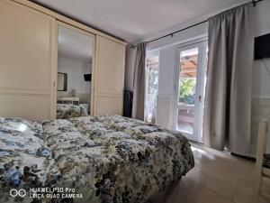 um quarto com uma cama e uma grande janela em villa di charme con piscina e jacuzzi tra Roma e Viterbo em Fabrica di Roma