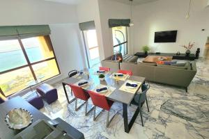 a living room with a table and a couch at Luxury Sea View Beachfront 3 Bedroom Apt, JBR in Dubai