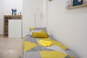 a bedroom with a bed with yellow pillows on it at CA' FIORE - Self check-in, central & modern in Como