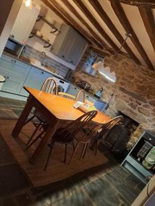 a wooden table and chairs in a kitchen at Animal Sanctuary Holiday Pen Bryn Twrw - Charity in Conwy