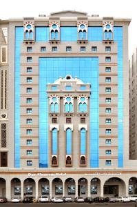 a reflection of a building with cars in front of it at Dar Al Naem Hotel in Al Madinah
