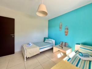 a room with two beds and a blue wall at Sermilie Beach Houses in Psakoudia