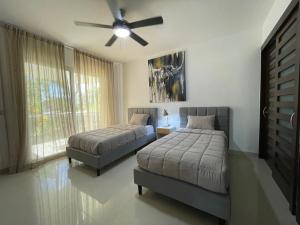 a bedroom with two beds and a ceiling fan at Stunning Ocean Front By Condo Boutique in Playa del Carmen
