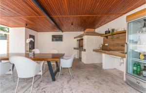 a kitchen with a wooden ceiling and a table and chairs at Beautiful Home In Biograd With Wifi in Biograd na Moru