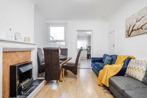 ein Wohnzimmer mit einem Sofa und einem Kamin in der Unterkunft 4 bedroom House Free Parking Contractor's Haven in Chelmsford