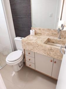 y baño con aseo blanco y lavamanos. en Residencial North Paradise 106, en Florianópolis