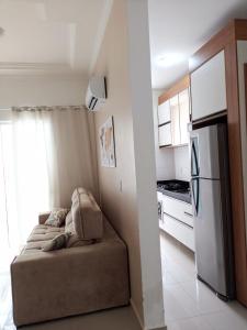 uma pequena cozinha com um sofá e um frigorífico em Residencial North Paradise 106 em Florianópolis