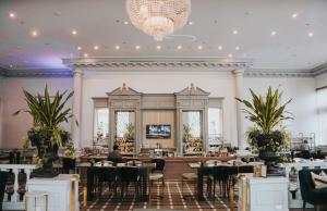 a restaurant with tables and chairs and a chandelier at Fairmont Chateau Laurier Gold Experience in Ottawa