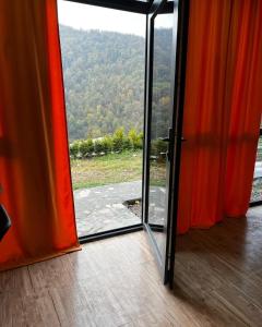 una puerta de cristal abierta con vistas a la montaña en Green Villa Resort Orange, en Dilijan