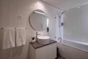 a white bathroom with a sink and a mirror at Island Retreat Apt (city center) in Ponta Delgada +19 photos