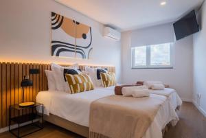 a bedroom with two beds and a tv on the wall at Island Retreat Apt (city center) in Ponta Delgada