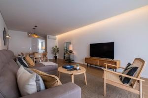 a living room with a couch and a flat screen tv at Island Retreat Apt (city center) in Ponta Delgada