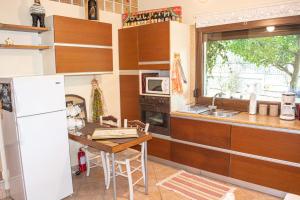 a kitchen with a table and a white refrigerator at Sofia's House in Paleo Tsifliki