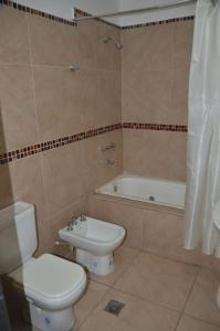 a bathroom with a toilet and a sink and a tub at Apartamentos El Mirador in El Carmen