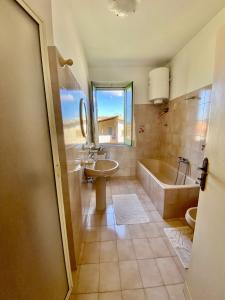 uma casa de banho com uma banheira e um lavatório e uma banheira em La Bouganville B&B em Acconia