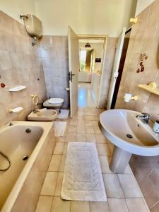 ein Badezimmer mit einer Badewanne, einem Waschbecken und einem WC in der Unterkunft La Bouganville B&B in Acconia