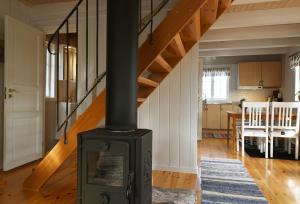 a wood stove in a living room with a staircase at Genuine house on northern Gotland near Slite in Lärbro