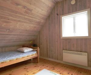 a bedroom with wooden walls and a bed and a window at Genuine house on northern Gotland near Slite in Lärbro