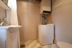 a small bathroom with a sink and a white refrigerator at Genuine house on northern Gotland near Slite in Lärbro