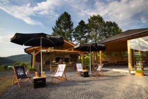 a group of chairs and umbrellas on a patio at Hotel Beskid BALNEO Medical Resort & SPA in Piwniczna-Zdrój