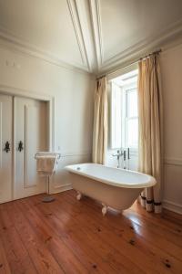 a white bath tub in a room with a window at Hotel Casa Palmela - Small Luxury Hotels of The World, Hotel & Villas in Setúbal