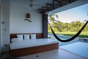 une chambre avec un lit et un hamac dans l'établissement Stunning Ocean Front By Condo Boutique, à Playa del Carmen