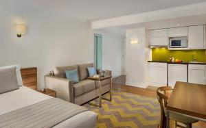 a hotel room with a bed and a kitchen at Citadines South Kensington London in London